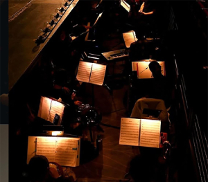 a dimly lit orchestra setting with sheet music